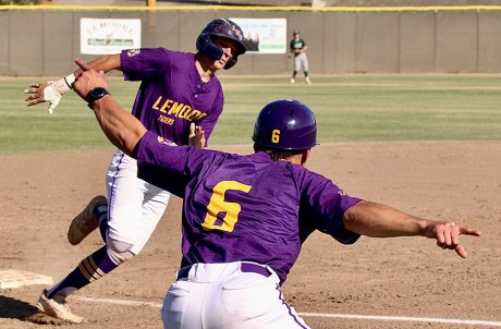 Coach Scott Loper waves home runner Andrew Mora for the go-ahead run.